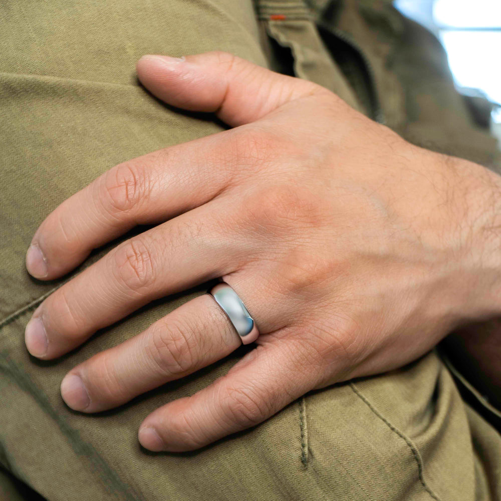 Closeup of a man wearing "The Maverick" tungsten ring in polished silver wearing a green jacket and resting his hand on his arm