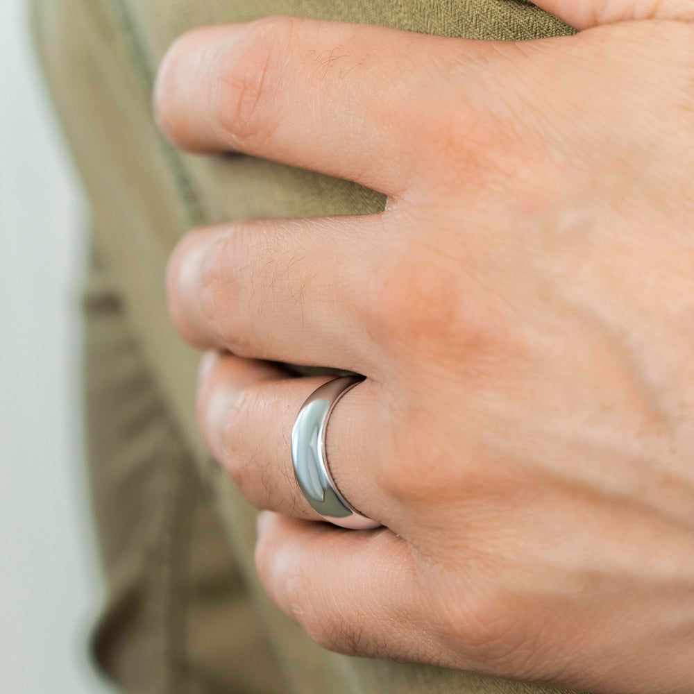 Closeup of a man wearing "The Maverick" tungsten ring in polished silver wearing a green jacket and resting his hand on his arm