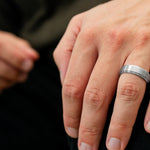 The Gentleman brushed silver tungsten ring worn on a man’s hand in an everyday lifestyle setting