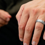 The Gentleman brushed silver tungsten ring worn on a man’s hand in an everyday lifestyle setting