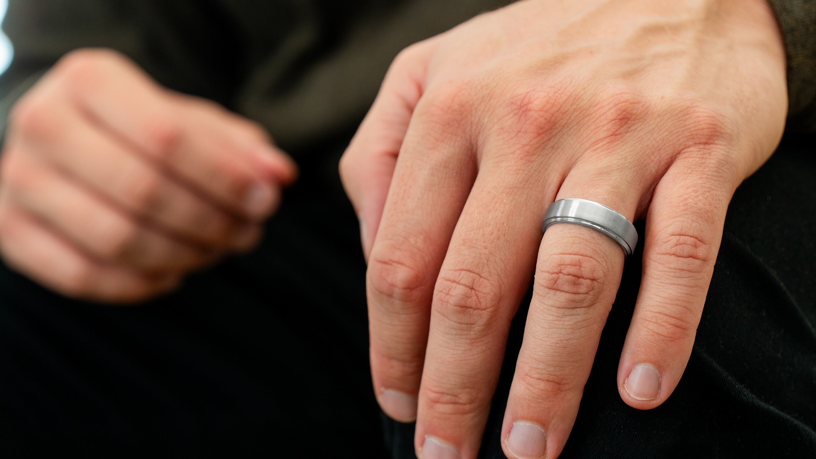 The Gentleman brushed silver tungsten ring worn on a man’s hand in an everyday lifestyle setting